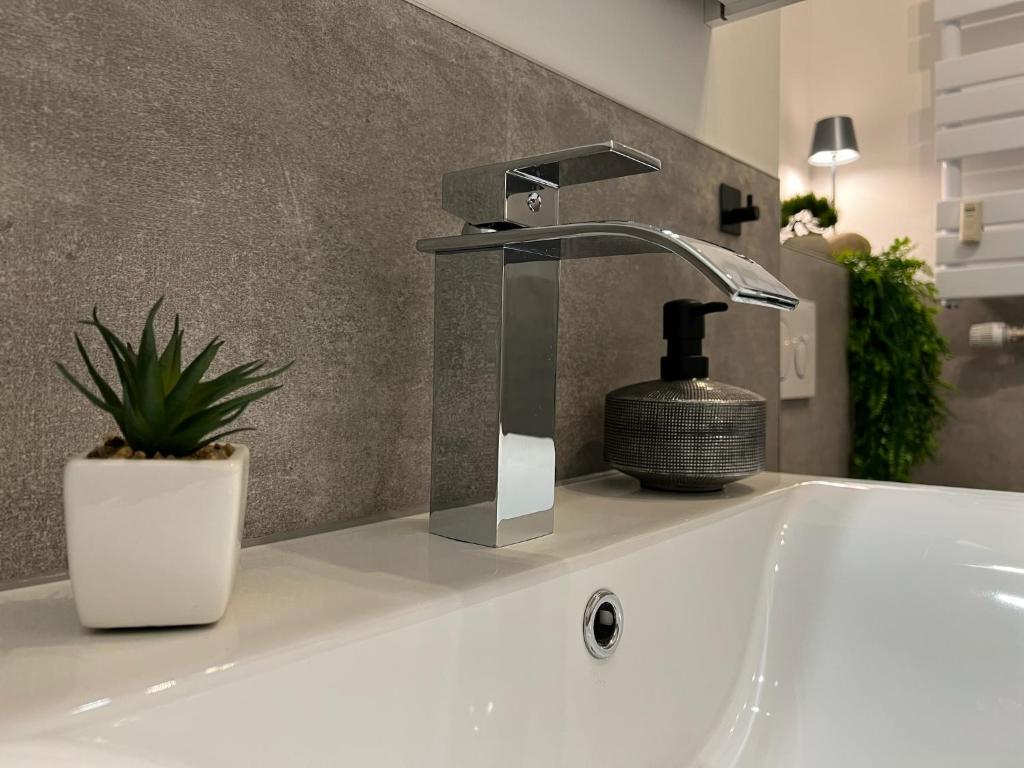 een wastafel in een badkamer met een kraan bij W&D living - FeWo Kleines Italien mit Parkplatz und Balkon in Celle