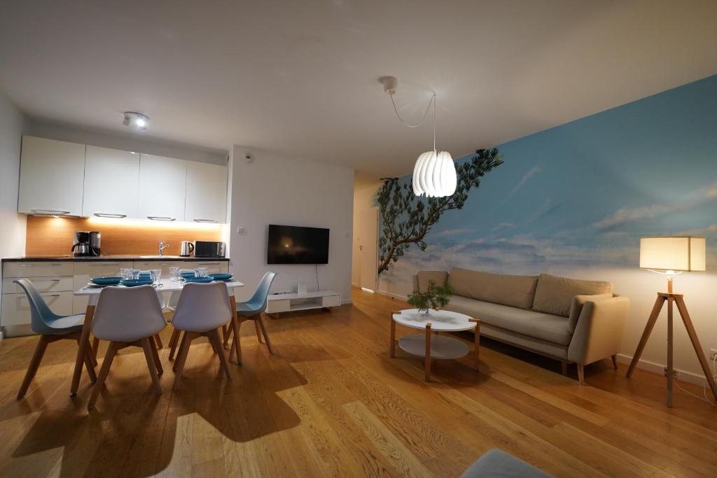 a living room with a couch and a table and chairs at Apartament przy plaży 3 in Mielno