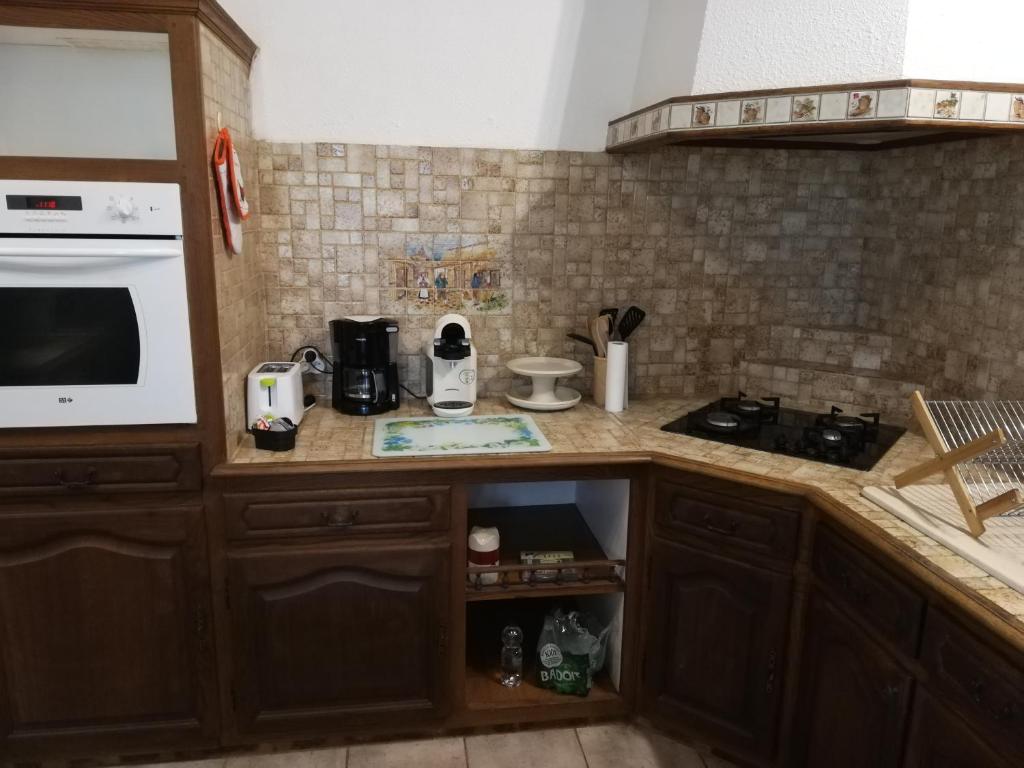 a kitchen with a counter with a stove and a microwave at L&#39;éveil in Vittefleur