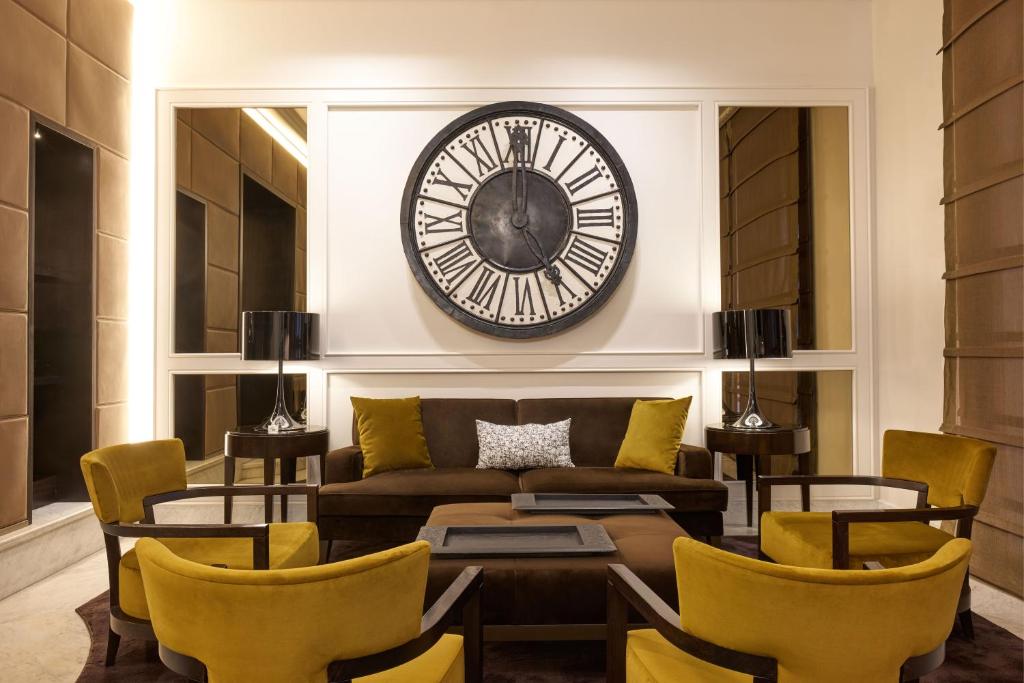 a living room with a couch and a clock on the wall at Hotel Mascagni in Rome