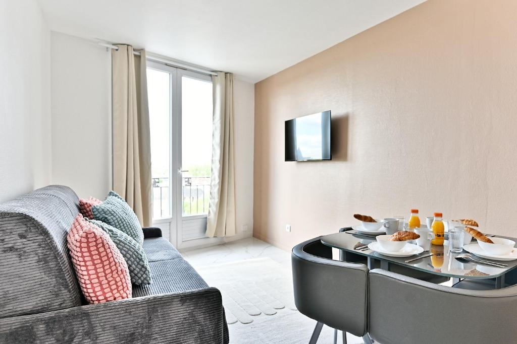 a living room with a couch and a table at Appartement moderne proche Paris - Gagny in Gagny