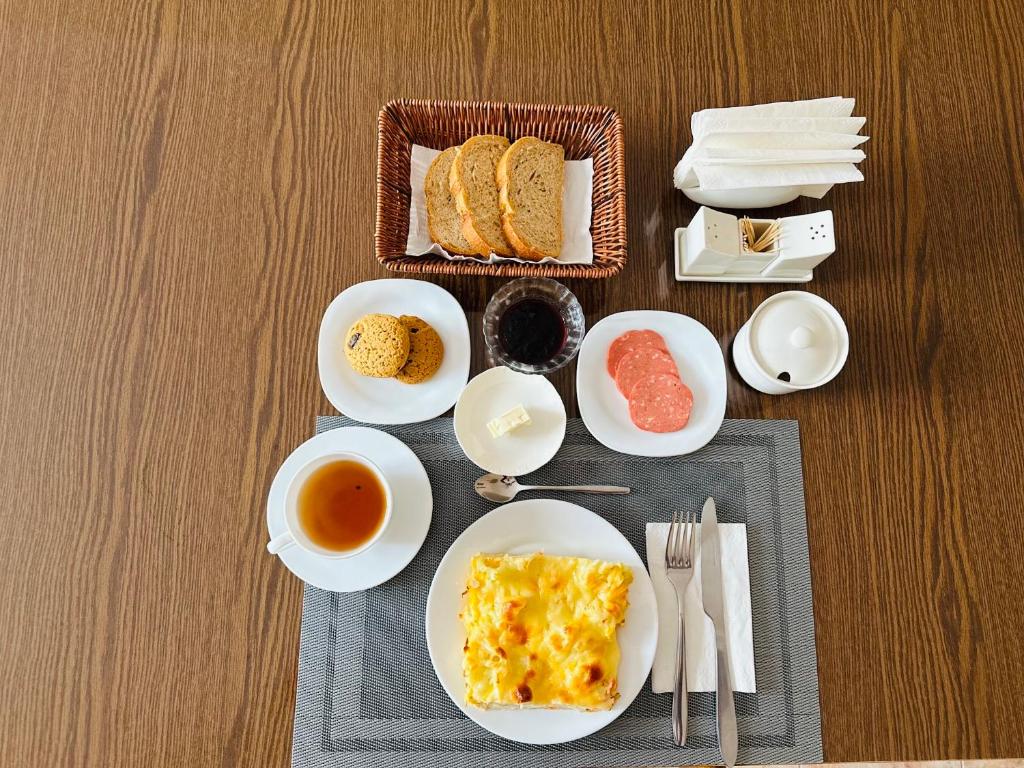 una mesa con platos de comida y tazas de té en Guest House Crocus, en Bishkek