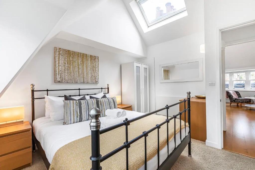 1 dormitorio con 1 cama y tragaluz en Pass the Keys Barbican Gem en Londres