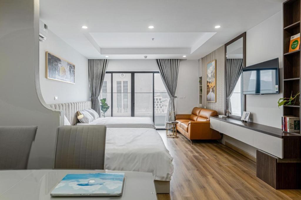 um quarto de hotel com duas camas e um sofá em TMS Luxury Residence Quy Nhơn em Quy Nhon