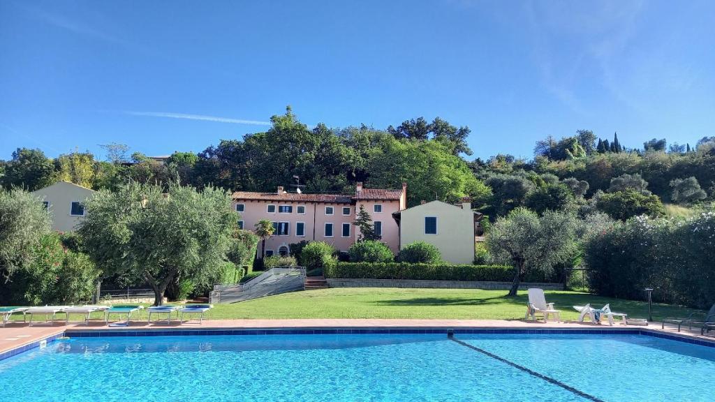 eine Villa mit einem Pool und einem Haus in der Unterkunft Bardolino Paerno Bilocale in Bardolino