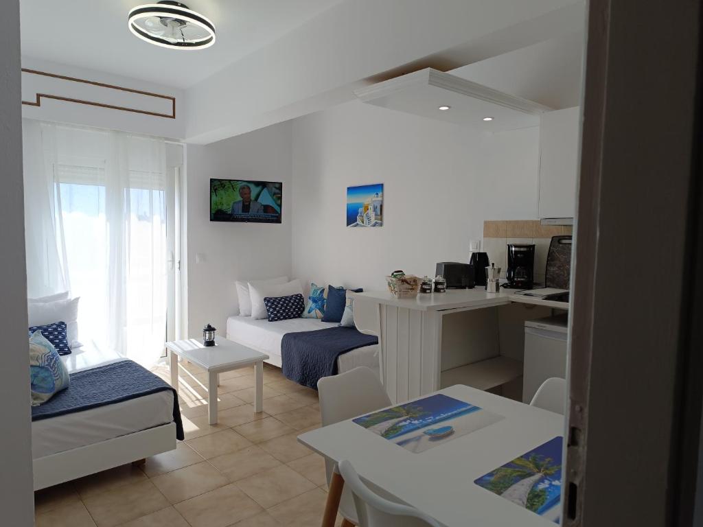 een witte woonkamer met een bank en een tafel bij Nautilus City Studios & Apartments in Rhodos-stad