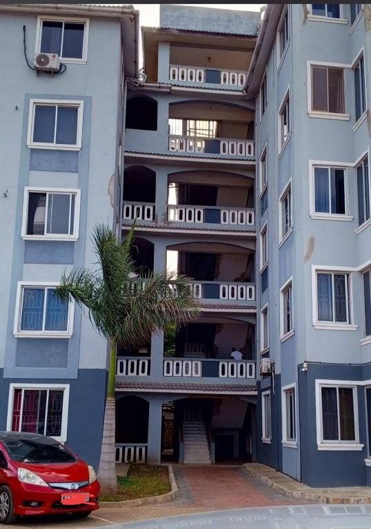 an apartment building with a car parked in front of it at Rina Crystal Accommodation in Mombasa