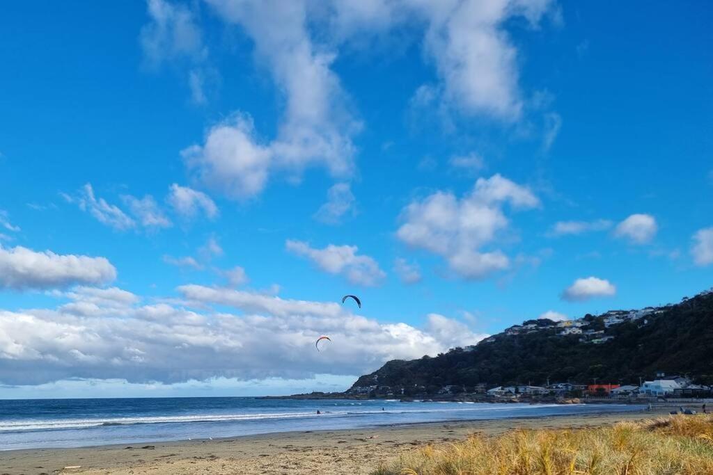 dos personas están volando cometas en la playa en Beachside Retreat, en Wellington