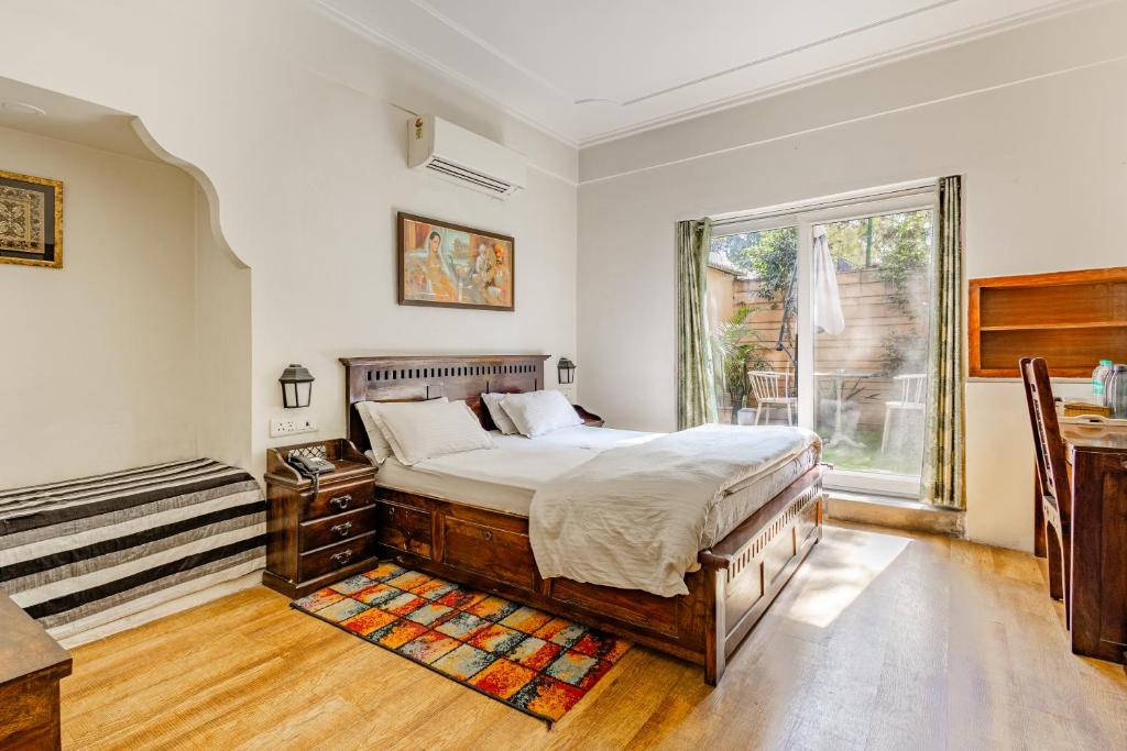 Un dormitorio con una cama grande y una ventana en Cp Villa - Rooms with Patio en Nueva Delhi