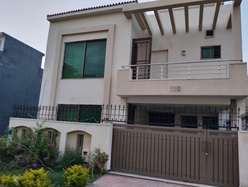 a house with a fence in front of it at Peridot Vacation Inn, Bahria in Islamabad