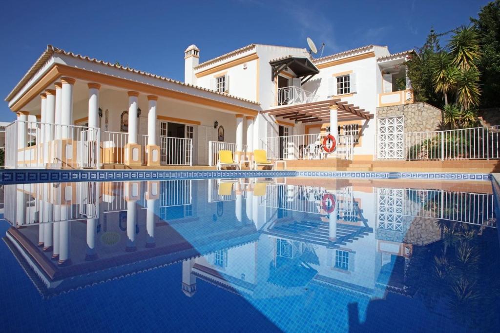 duży dom z basenem przed nim w obiekcie Villa Jumar w Albufeirze
