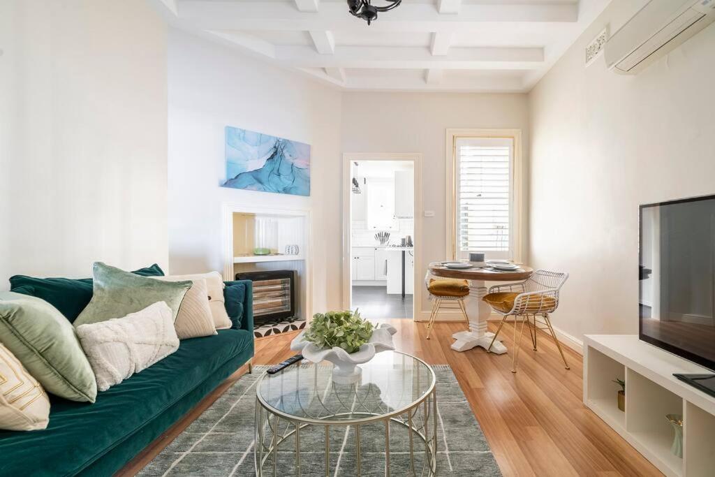 a living room with a green couch and a table at Green Stays in Sydney