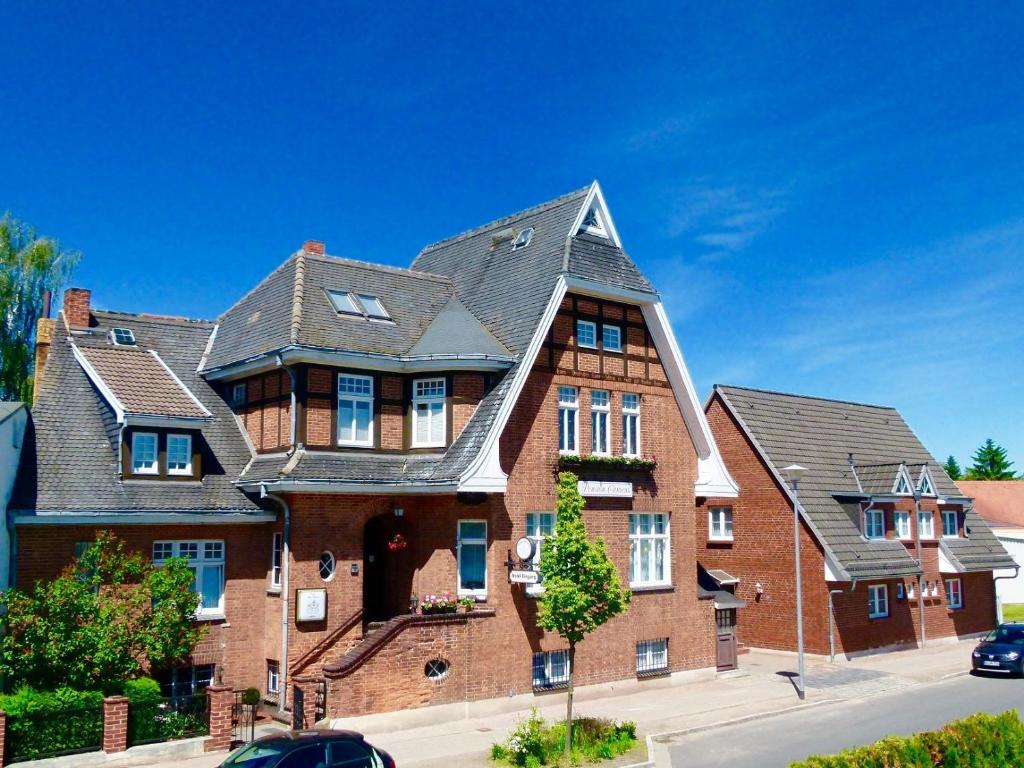 a large red brick house with a gray roof at Hotel & Pension Villa Camenz in Güstrow