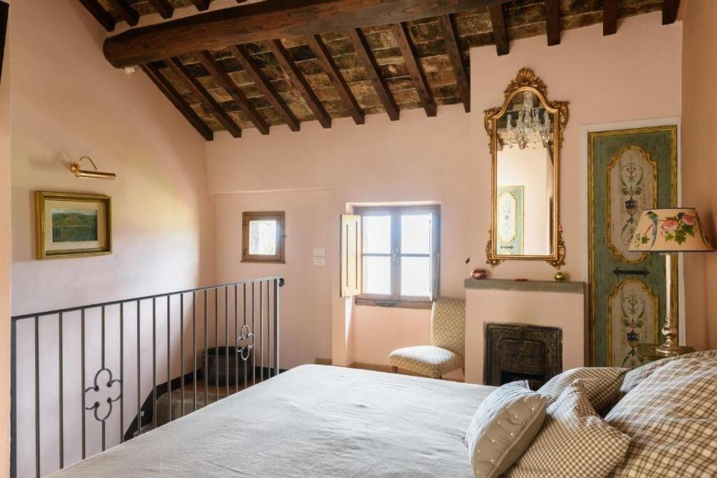 Schlafzimmer mit einem Bett und einem Wandspiegel in der Unterkunft Deliziosa casetta in centro! in Cortona