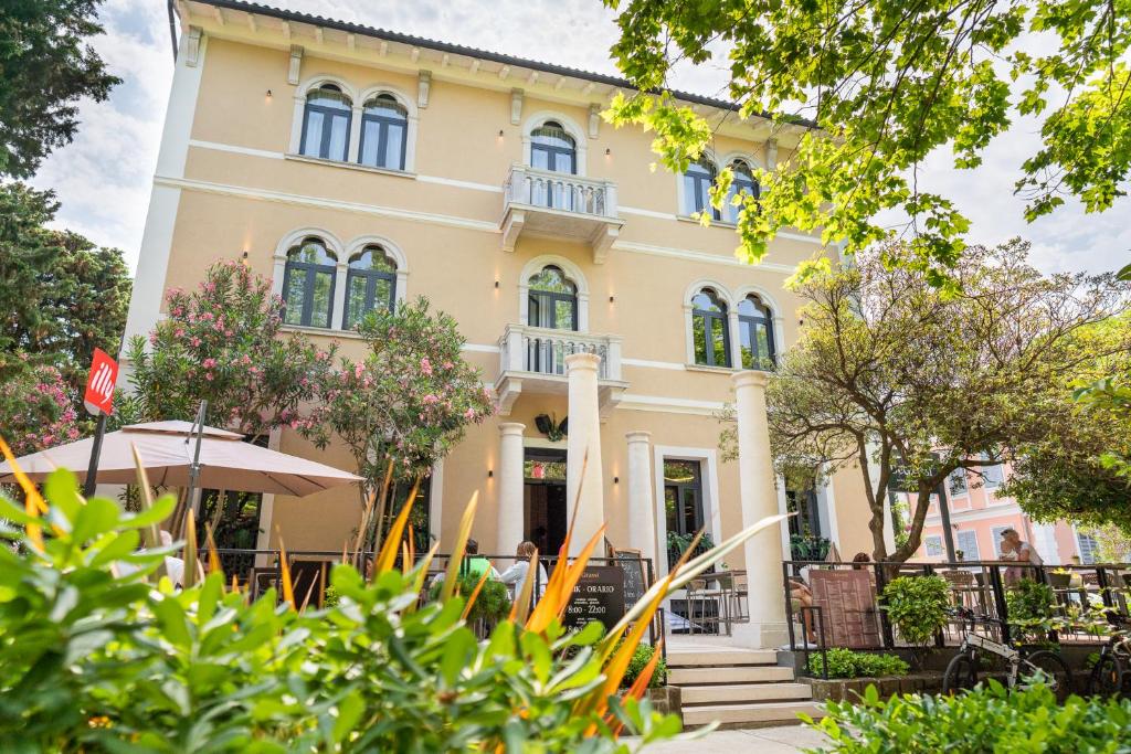 a building with trees in front of it at DeGrassi Boutique Garni Hotel Izola in Izola