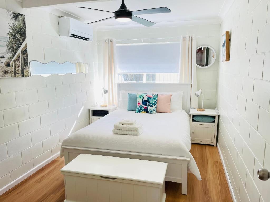 a small bedroom with a bed and a window at Brooms Beach Stay in Brooms Head