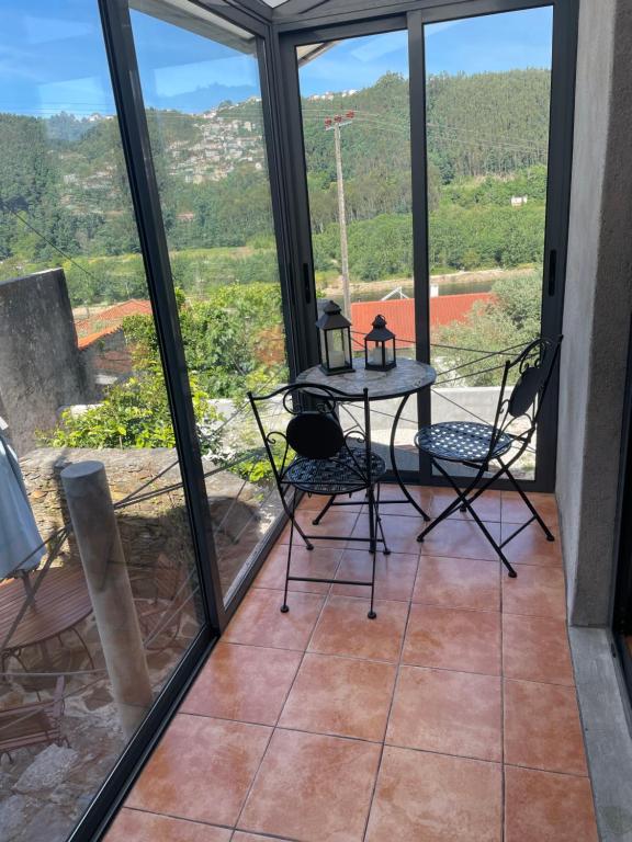 Pokój ze stołem i krzesłami na balkonie w obiekcie Cantinho do Barroco w mieście Penacova