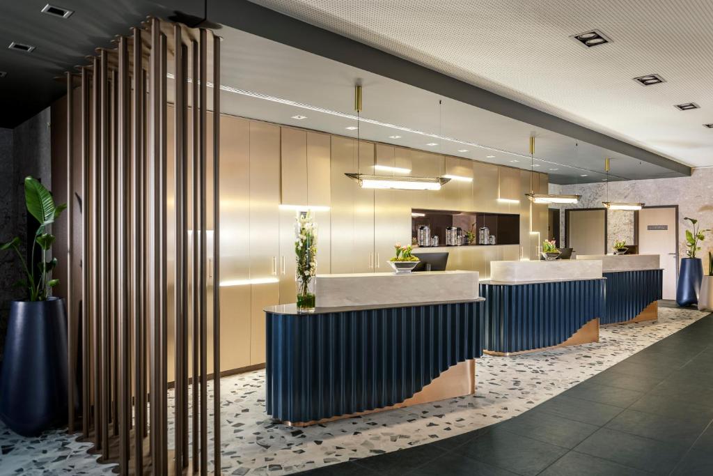 a lobby with a reception area with blue and white at NH Berlin Kurf&uuml;rstendamm in Berlin