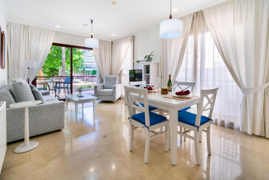 ein Wohnzimmer mit einem weißen Tisch und Stühlen in der Unterkunft Apartamentos Albir Confort - Avenida 1 dorm in Albir