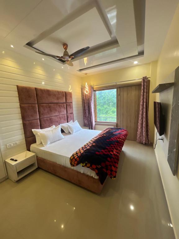 a bedroom with a large bed and a window at Shomaan boutique hotel in Sundarnagar