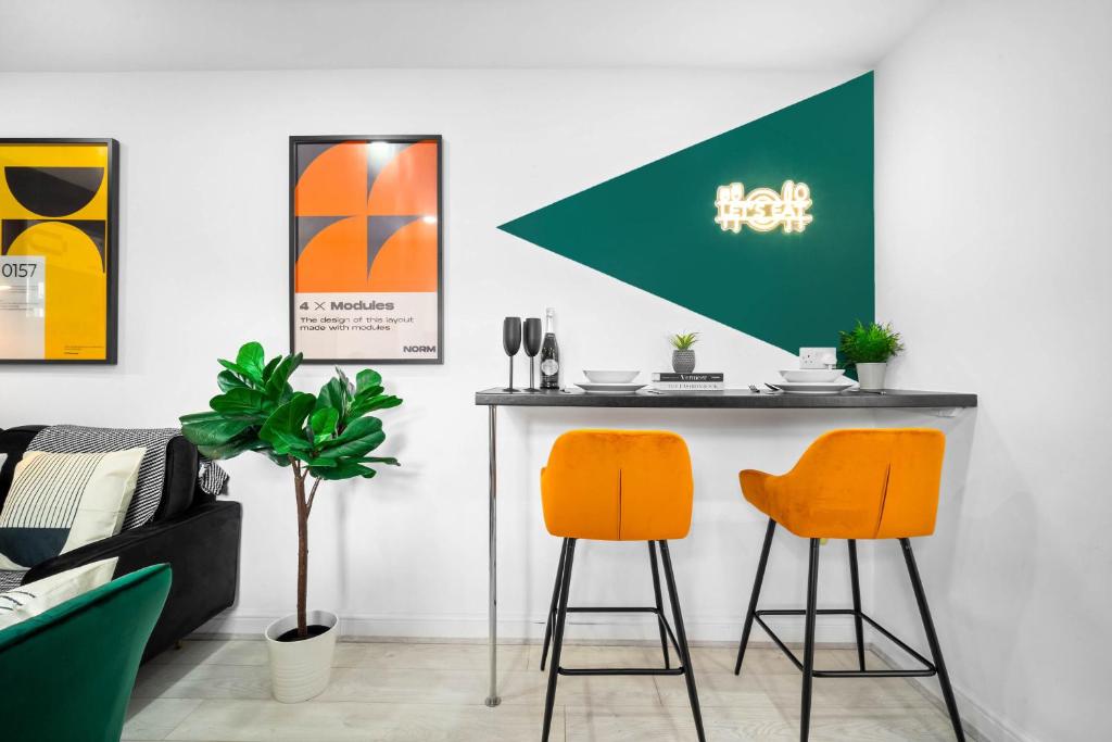 un bar con 2 sillas naranjas en una habitación en Luxury 3 Bedroom Apartment - Terrace - WiFi - Smart TV 1MR en Birmingham