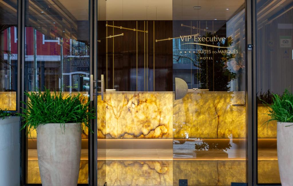 a store window with two potted plants in front of it at VIP Executive Suites do Marquês Hotel in Lisbon