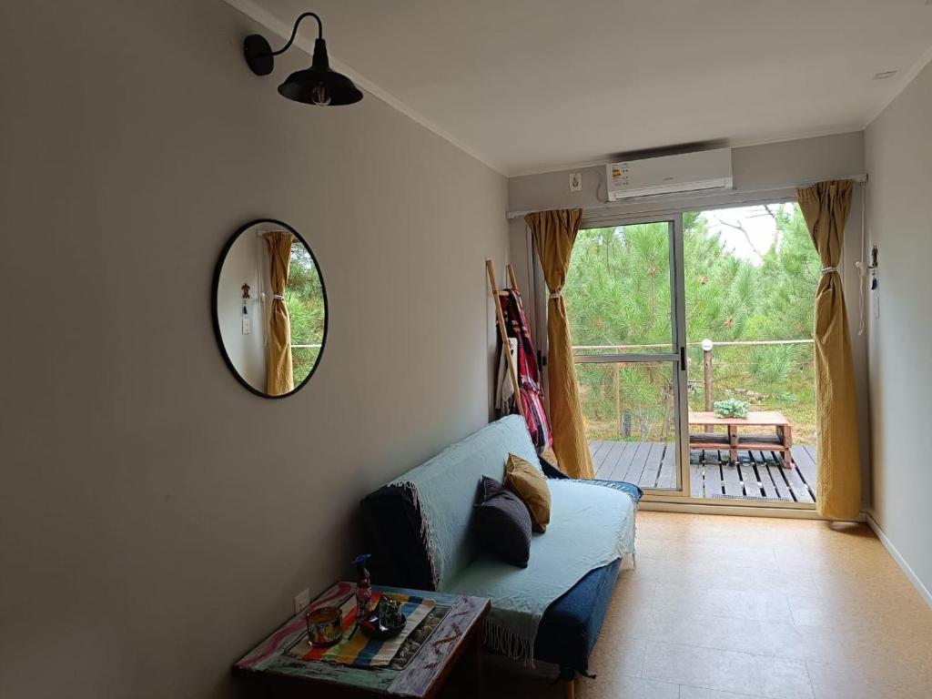 a living room with a blue couch and a mirror at Frente a la playa en El Pinar in Ciudad de la Costa