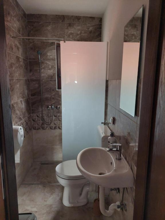 ein Bad mit einem WC, einem Waschbecken und einer Dusche in der Unterkunft Restoran BMB in Odžak