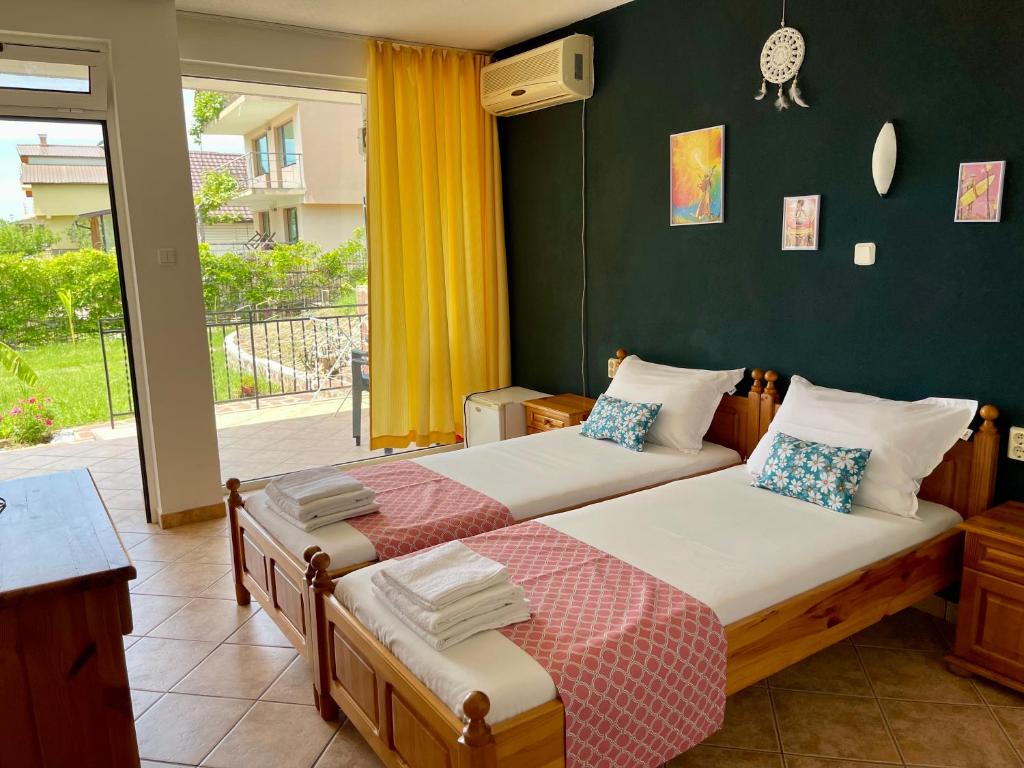 two beds in a bedroom with a green wall at Guesthouse Serenity hill in Sveti Vlas