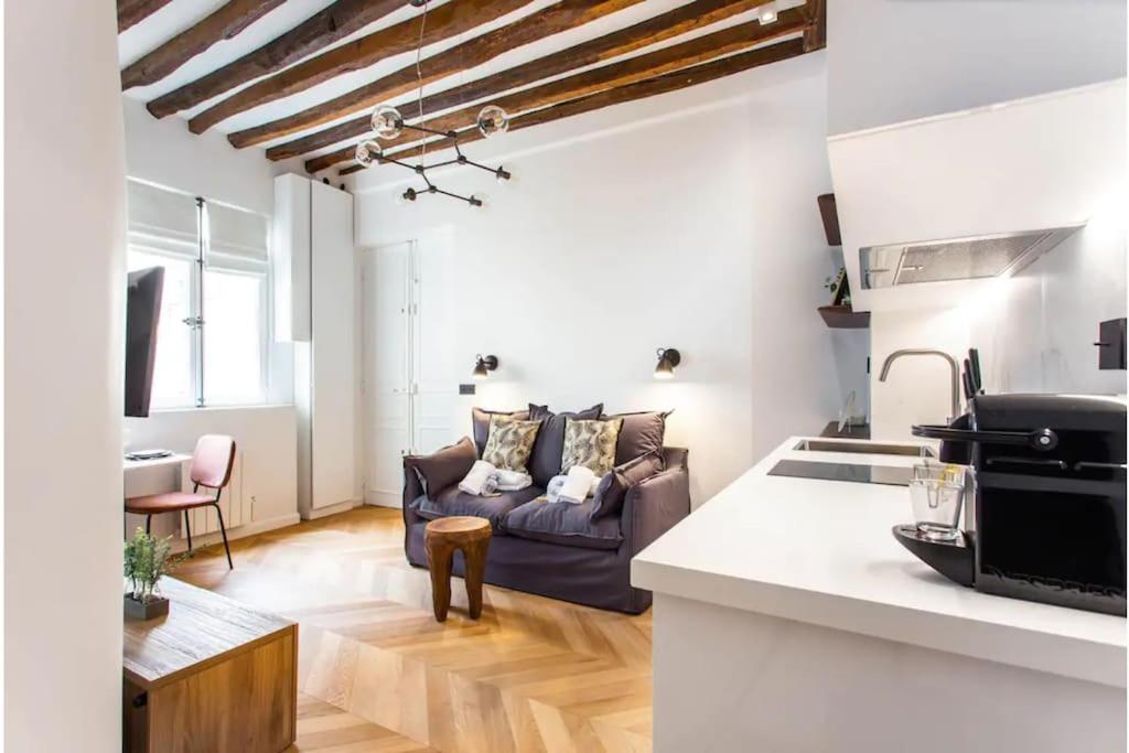 un salon avec un canapé et une cuisine dans l'établissement Central Studio Tronchet, à Paris