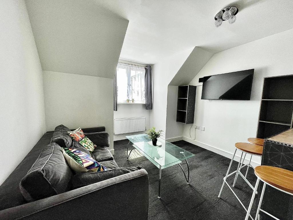 ein Wohnzimmer mit einem Sofa und einem Tisch in der Unterkunft Crescent Loft Apartment - 1 Bedroom in Goodmayes