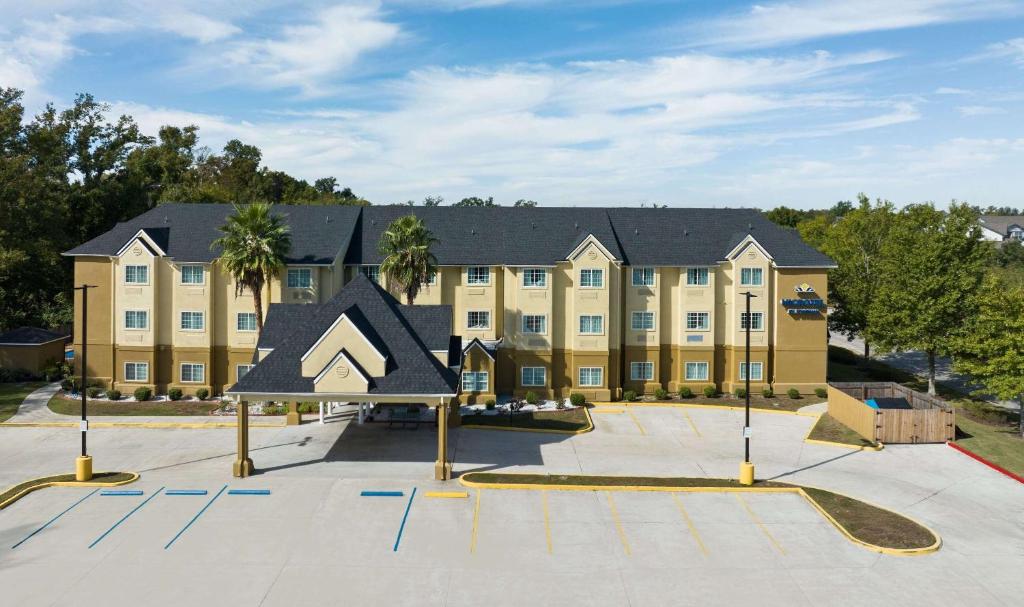 - un grand bâtiment avec une aire de jeux en face dans l'établissement Microtel Inn & Suites by Wyndham of Houma, à Houma