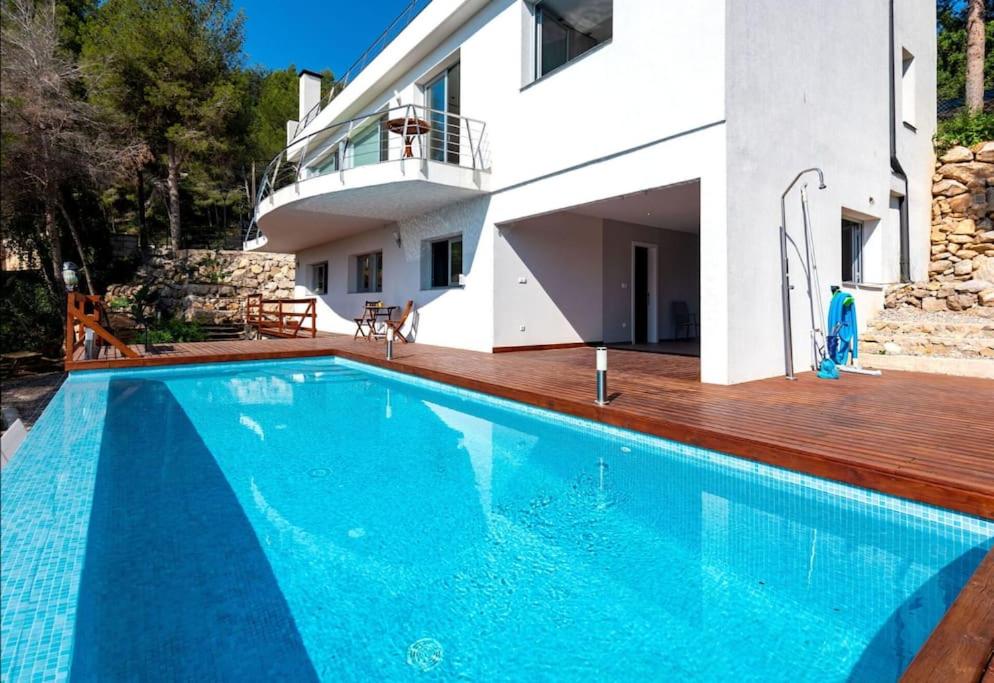 a swimming pool in front of a house at Casa Majestic in Cunit