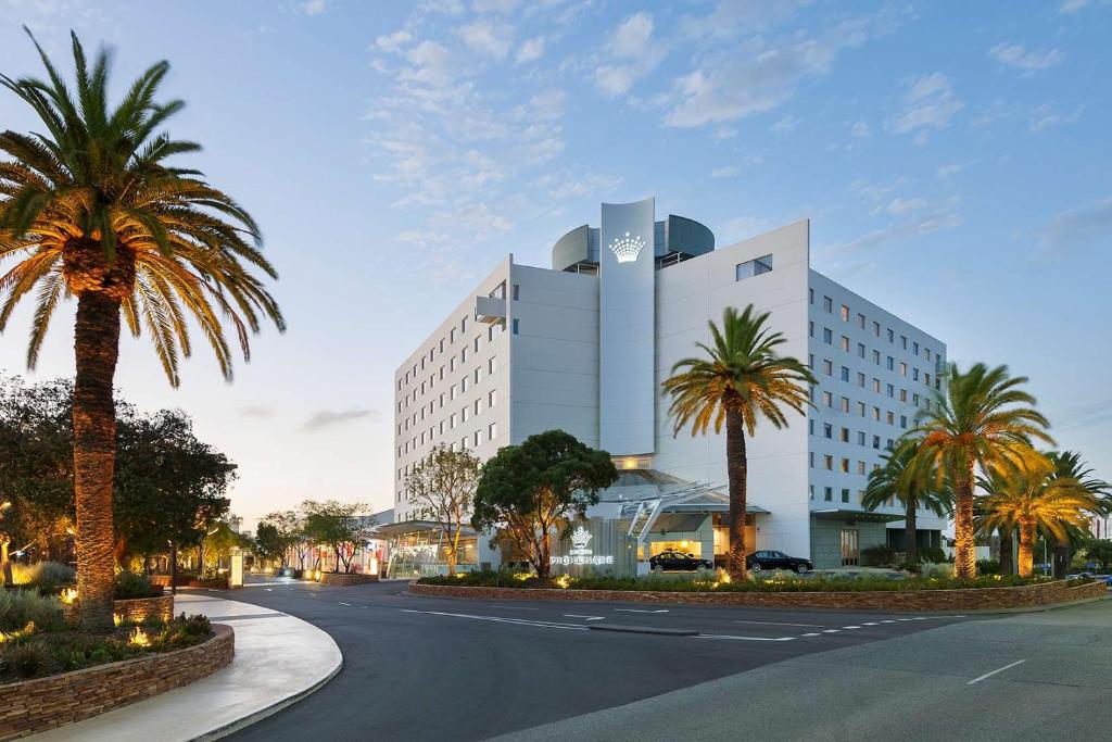 um grande edifício branco com palmeiras em frente em Crown Promenade Perth em Perth