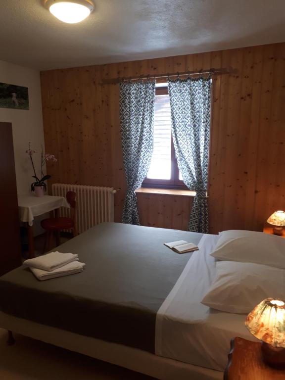 Un dormitorio con una cama grande y una ventana en Le Chalet, en Lamoura