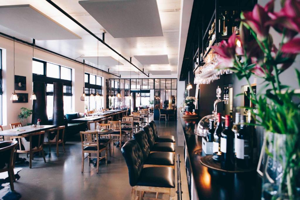 un ristorante con divani, tavoli, sedie e fiori di Eyja Guldsmeden Hotel a Reykjavik