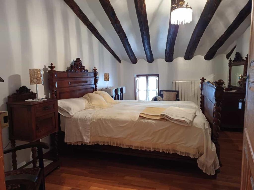 1 dormitorio con 1 cama grande y techo de madera en CASA RURAL SANCHO en Artajona