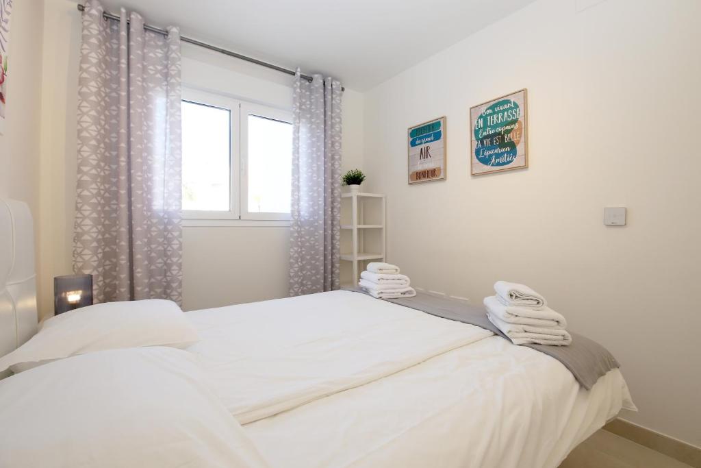 biała sypialnia z łóżkiem i oknem w obiekcie Apartment BEATRIX w mieście Estepona