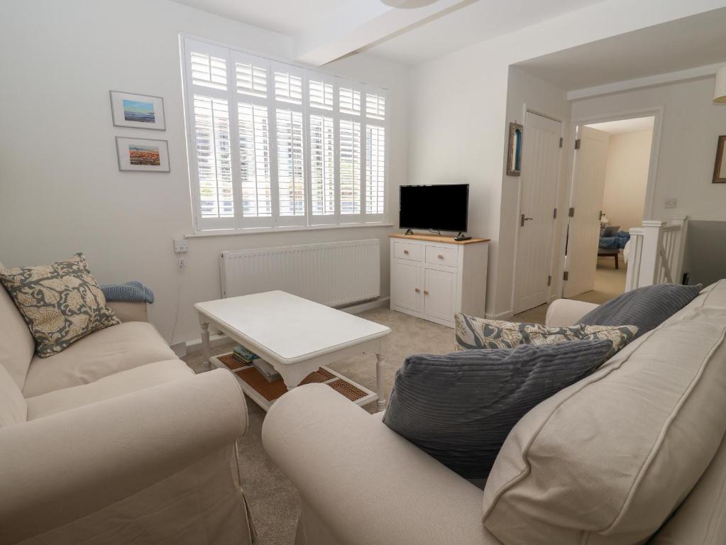a living room with two couches and a table at 16 Church Street in Lyme Regis