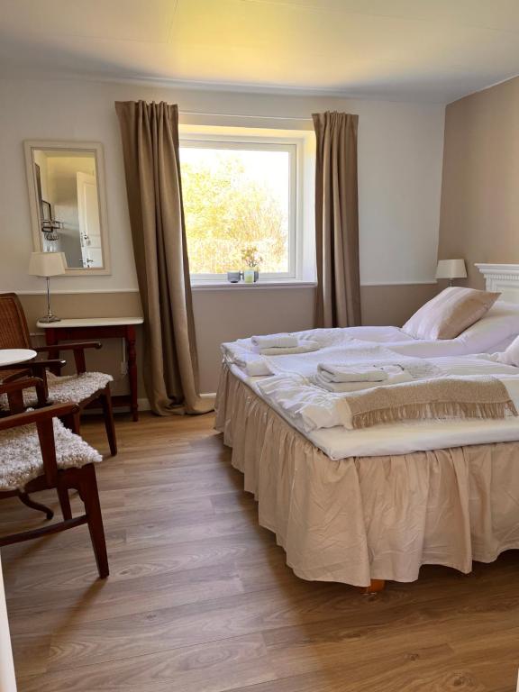 ein Schlafzimmer mit einem großen Bett und einem Fenster in der Unterkunft Munkgaard INN & OUTDOOR in Rødvig