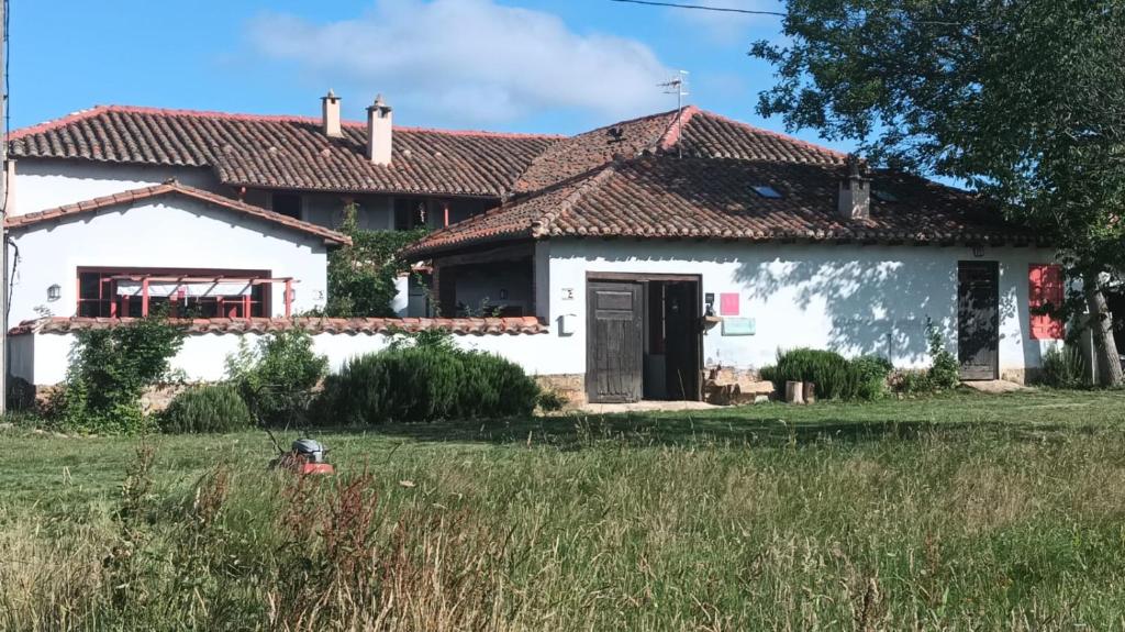 een wit huis met een rood dak bij La Madrigata al completo in Revilla de Cepeda