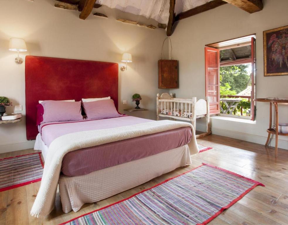 a bedroom with a large bed with a red headboard at Apartamento Coral in Revilla de Cepeda