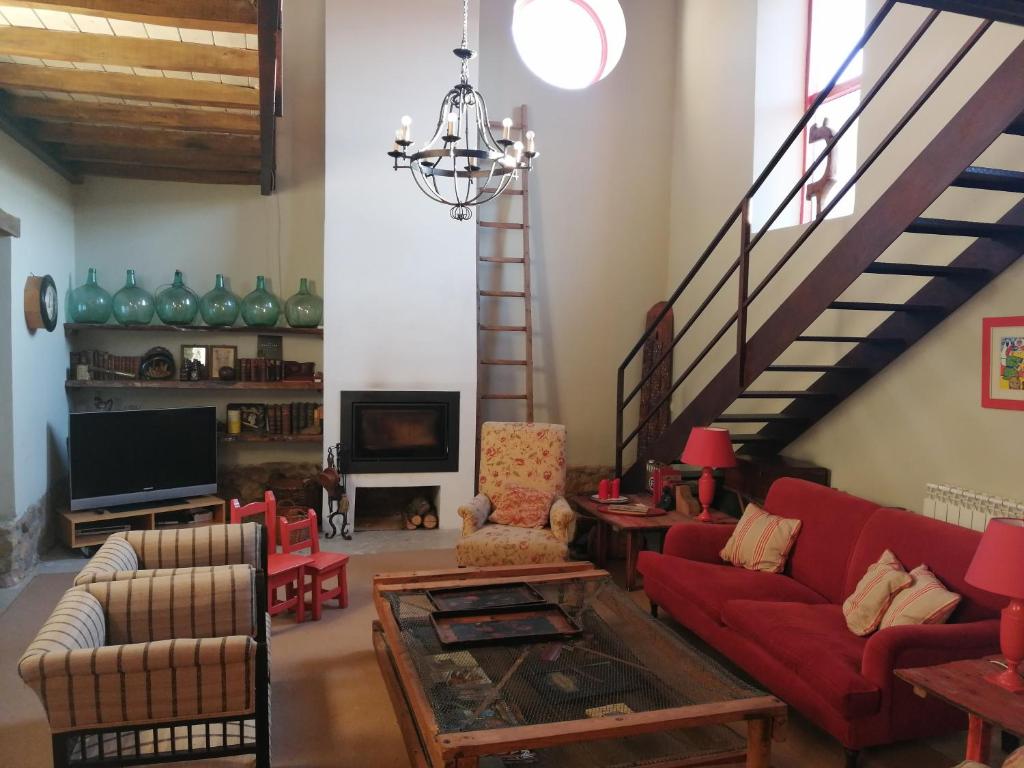 een woonkamer met rode banken en een trap bij Casa Grande in Revilla de Cepeda