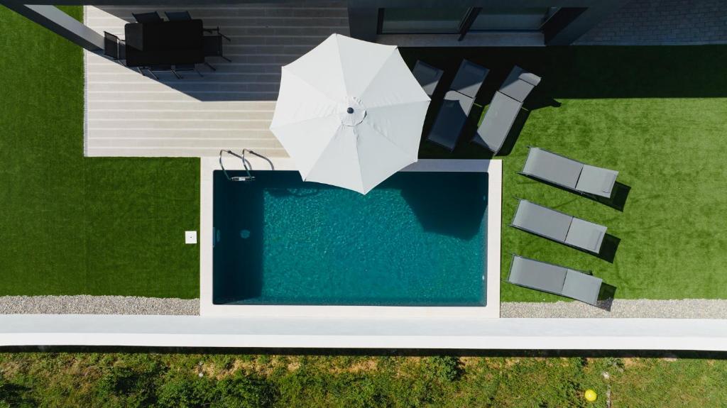 an overhead view of a pool with an umbrella and chairs at Yama House 