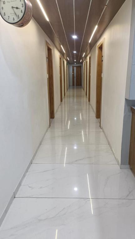 um corredor vazio com um relógio na parede em hotel gateway inn em Ahmedabad