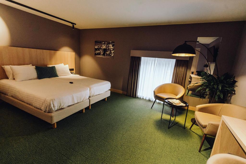 une chambre d'hôtel avec un lit, une table et des chaises dans l'établissement Hôtel Five Nations, à Durbuy