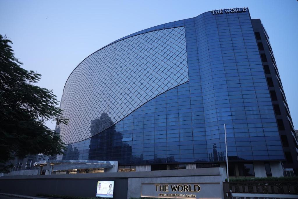 a large glass building with a sign in front of it at The World Surat in Surat