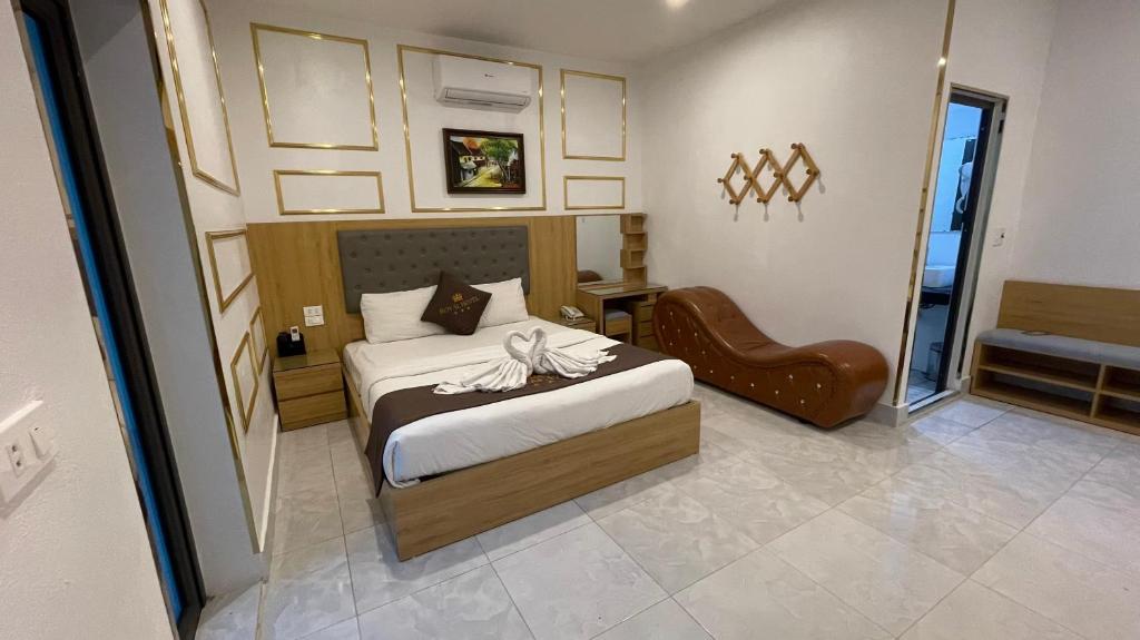een slaapkamer met een bed en een stoel bij Royal Hotel Vĩnh Phúc in Vĩnh Phúc