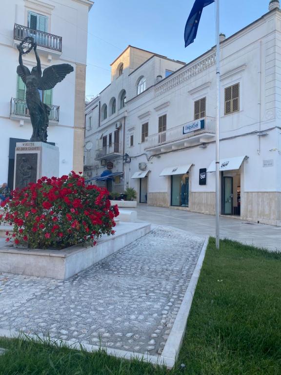 uma estátua em frente a um edifício com flores em Monolocale Elena em Vieste