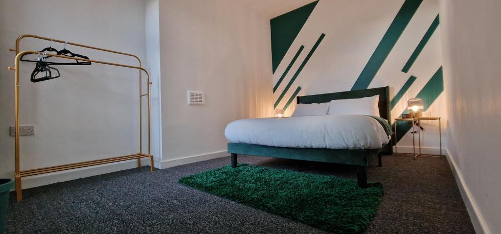 a bedroom with a bed and a green chair at Entire Modern Home in Manchester and Near Peak District in Manchester